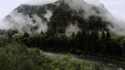 Aerial view over river and mountain on foggy day in PNW Stock Footage 241362525