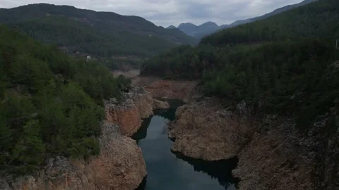 Aerial view over river in a small canyon with a panorama of the green mountains 動画素材 231023499