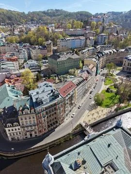 An aerial view over the rooftops of central Karlovy Vary toward the wooded hills Stock Photos