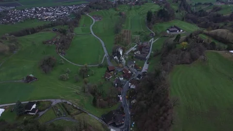 Aerial View Over Small Alpine Village With Winding Road Connection Stock-Footage 331742653
