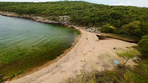 Aerial view over a small bay with a wild beach, located in the forest, Paraskeva Stock Footage 288034620