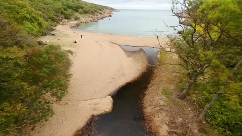 Aerial view over a small bay with a wild beach, located in the forest, Paraskeva Stock Footage 288034643