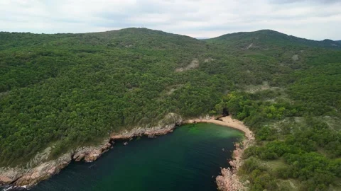 Aerial view over a small bay with a wild beach, located in the forest, Paraskeva Stock Footage 288034722