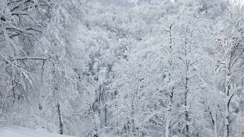 Aerial view over snowy mountain ridge valley with clouds, cable car lifting Video stock 101538745