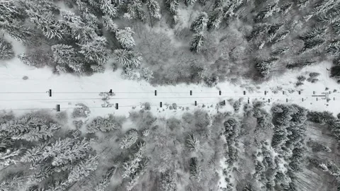 Aerial view over snowy mountain winter forest with chair lift at ski resort Stock Footage 194669654