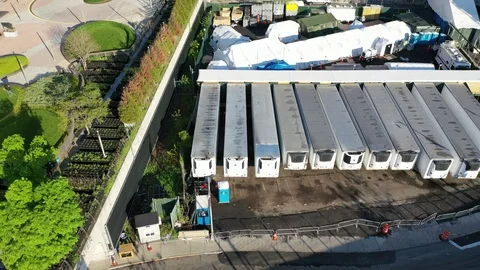 An aerial view over temporary morgue refrigeration trailers containing the Stock Footage 130014013