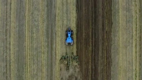 Aerial view over the tractor plows the land in the village. The process of pr Stock Footage 137263668