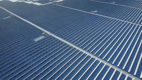 Aerial view over trees around snow covered solar cells with factory background Stock Footage 217747356