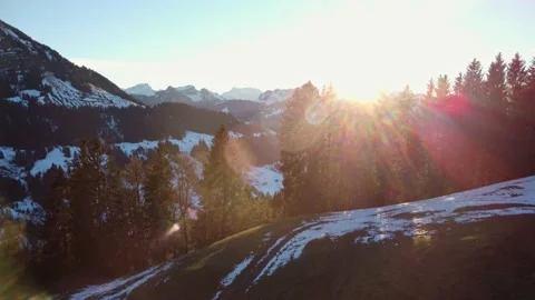 Aerial view over treetops in front of beautiful mountain range with lens flare Video stock 167983193