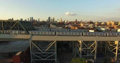 Aerial view over two subway trains on bridge in Brooklyn Manhattan skyline  NYC Video stock 172459468