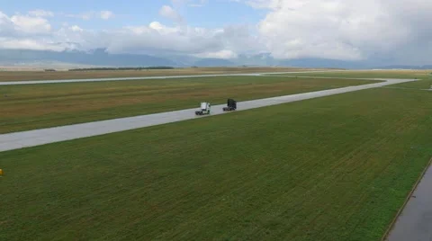 Aerial view over of two trucks, on the airport track Stock Footage 61323424