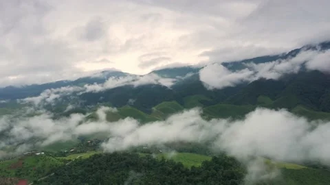Aerial view over valley surrounded by mountains and covered with fog and mist Stock Footage 141522593