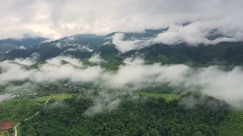 Aerial view over valley surrounded by mountains and covered with fog and mist Stock Footage 141522605