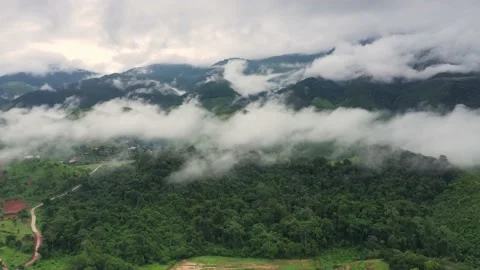 Aerial view over valley surrounded by mountains and covered with dense ground fo Stock Footage 142298451