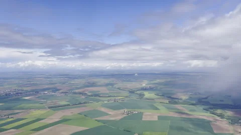 Aerial view over vast patchwork of green and brown agricultural fields with 動画素材 337949341