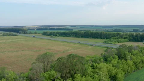 Aerial view overlooking a freeway with oncoming lanes. On the road going trucks Stock Footage 116809881