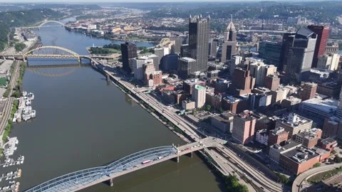 Aerial view overlooking the river bend, historic steel bridges, and commercial Vídeos de archivo 338434143