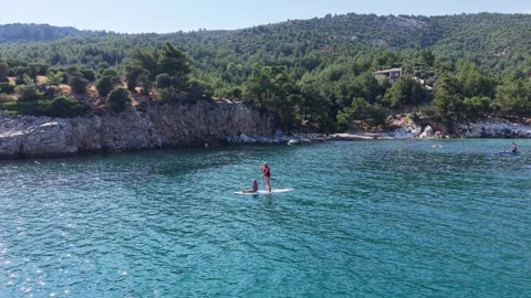 Aerial View of Paddleboarder Crossing Clear Blue Bay Stock Footage 340508327