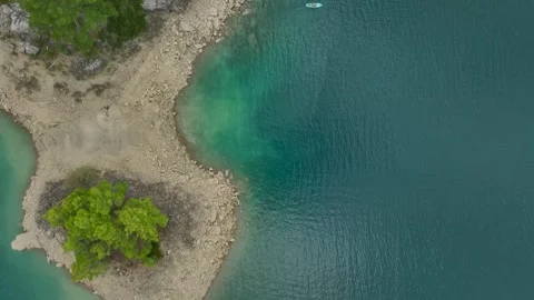 Aerial View: Paddleboarders explore emerald waters surrounded by rugged Stock Footage 296187320