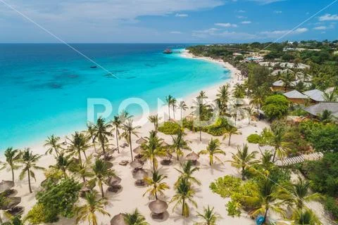 Aerial view of palms on the sandy beach of Indian Ocean at sunset Stock Photos