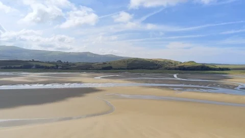 Aerial view, pan move. Drone panorama over low tide sea and sand. Green hills Video stock 94238610