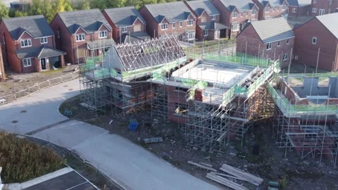 Aerial view panning across new build housing framework on construction Video stock 202492841