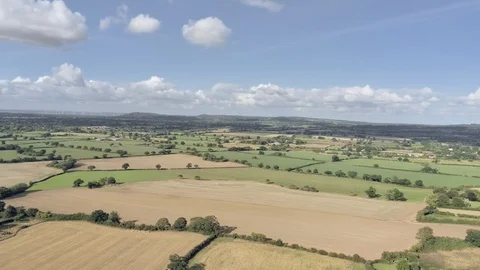 Aerial view, panning move. Fly over Cheshire fields, small town, Tarvin on a  Stock Footage 95564803