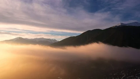 Aerial view of the panorama of snowy mountain peaks the rising mist at dawn Stock Footage 103314853