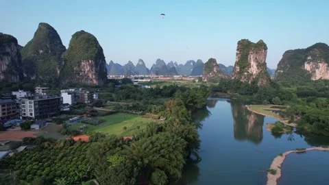 Aerial View of a Paraglider Gliding Above Towering Karst Peaks and River Scenery Stock Footage 341877341