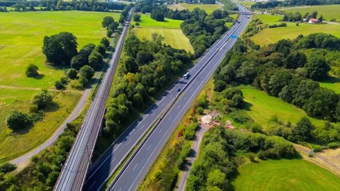Aerial view of parallel railway line and highway running through rural farmland Stock-Footage 315769928
