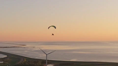 Aerial view of paramotor flight during scenic sunset across Dutch fields Stock Footage 313364628