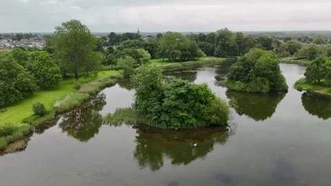 Aerial View of Park Lake With Tree Covered Island and Reflections 스톡 동영상 332668233