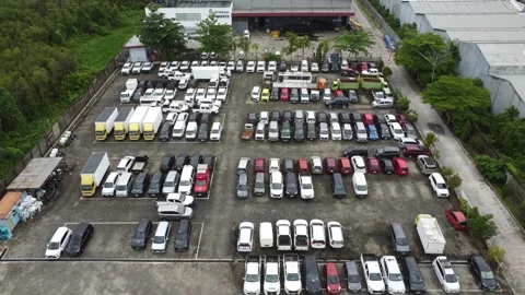 Aerial view of a parking lot lined up with cars for rent Stock Footage 325640332