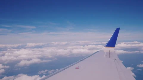 Aerial view from passenger airplane window showing wing against blue sky an.. Stock Footage 334560697
