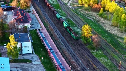 Aerial view of a passenger train and a cargo train at the station in golden Stock Footage 337792115