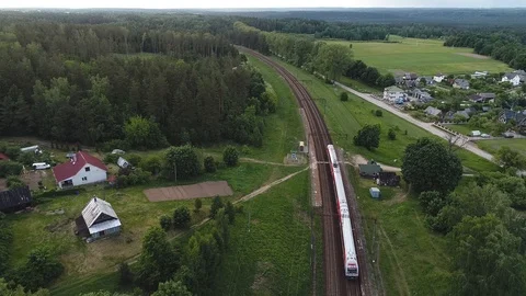 Aerial view of passenger train leaving the small village stop Stock Footage 104706700
