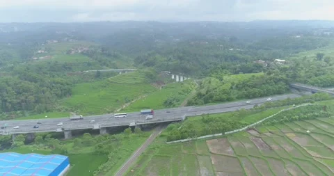 Aerial View of Passenger Train Passing by a Curved Rail and Rice Field Stock Footage 131102754