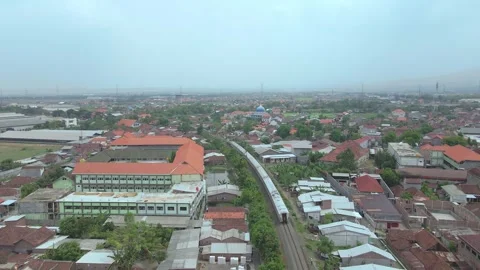 Aerial View of a Passenger Train Through a Dense Urban Residential Area Vídeo Stock 334764516