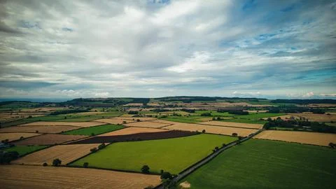 Aerial view of a patchwork of agricultural fields under a cloudy sky in Yor.. Photos