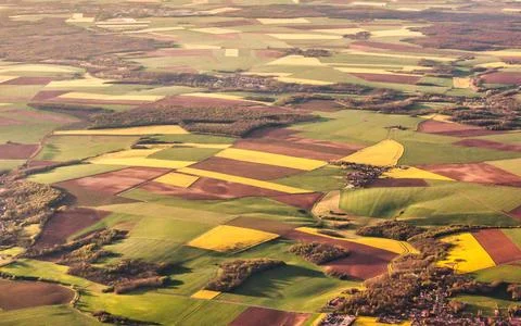 Aerial view of patchwork agricultural fields with vibrant green and yellow .. Stock Photos