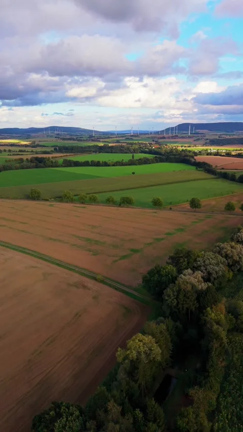 Aerial View Of Patchwork Farmland And Wind Turbines 動画素材 345113632