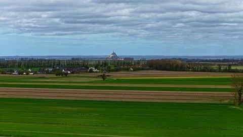 Aerial view of patchwork farmland leading toward Mont-Saint-Michel in Normandy Stock Footage 333327691
