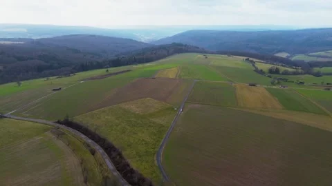 Aerial View of Patchwork Farmlands Stretching Across Rolling Hills Stock Footage 270212114
