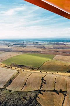 Aerial View of Patchwork Fields from an Aircraft on cloudy day Stock Photos