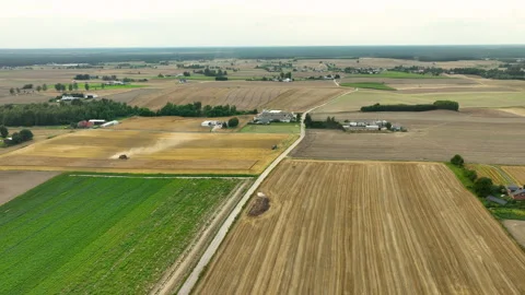 Aerial view of a patchwork of fields with a harvester in action. The Stock Footage 281644452