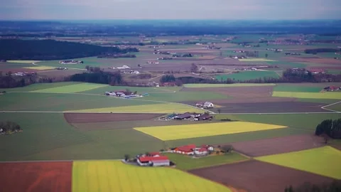 An aerial view of the patchwork of fields, towns, forests, and river banks Vídeos de archivo 274182624