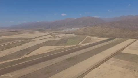 Aerial view of patchwork harvested fields in a mountain valley, Kyrgyzstan Stock Footage 347242521