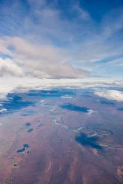 Aerial view of patchy clouds above a tundra landscape, a river cutting through t Foto stock