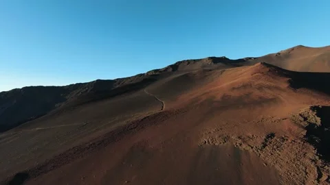 Aerial view of path crossing dark grey &amp; red volcano mountain during sunrise Video stock 196907772