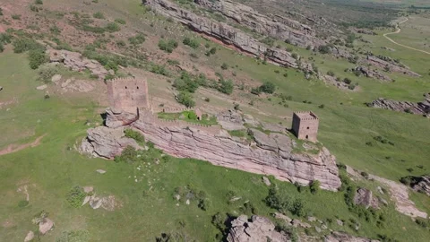 Aerial view of a path leading to a ruined hilltop tower Vídeos de archivo 343325761